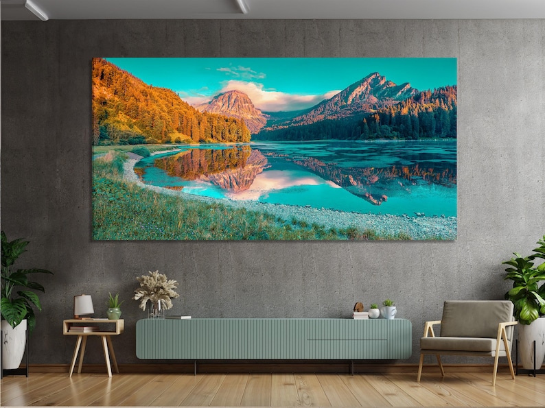 Mountain lake landscape with turquoise water reflecting peaks and autumn forest slopes