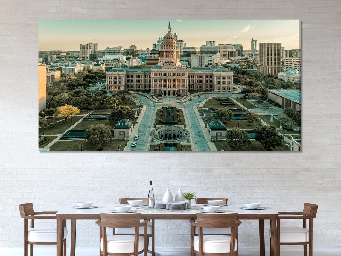 Room mockup with three multi-panel aerial city views above a sofa