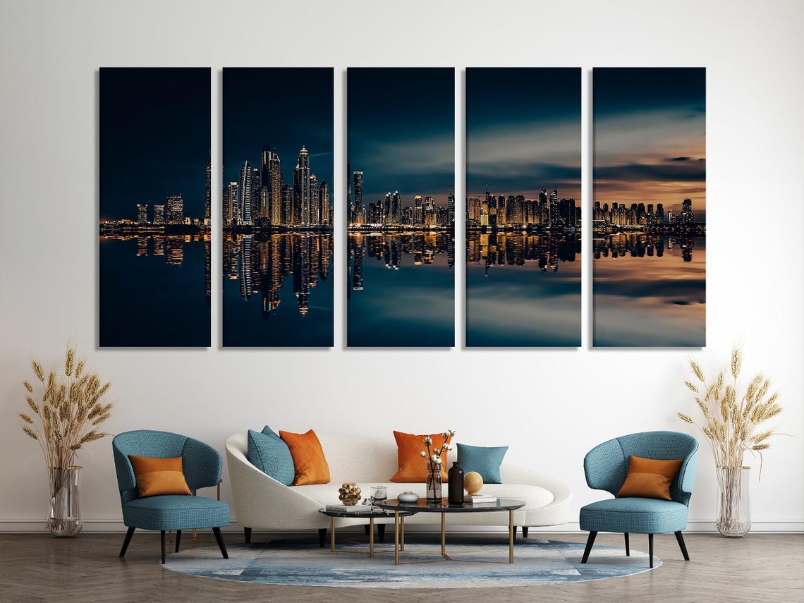 Night city skyline with warm gold lights reflected on dark water under a deep navy sky detail view