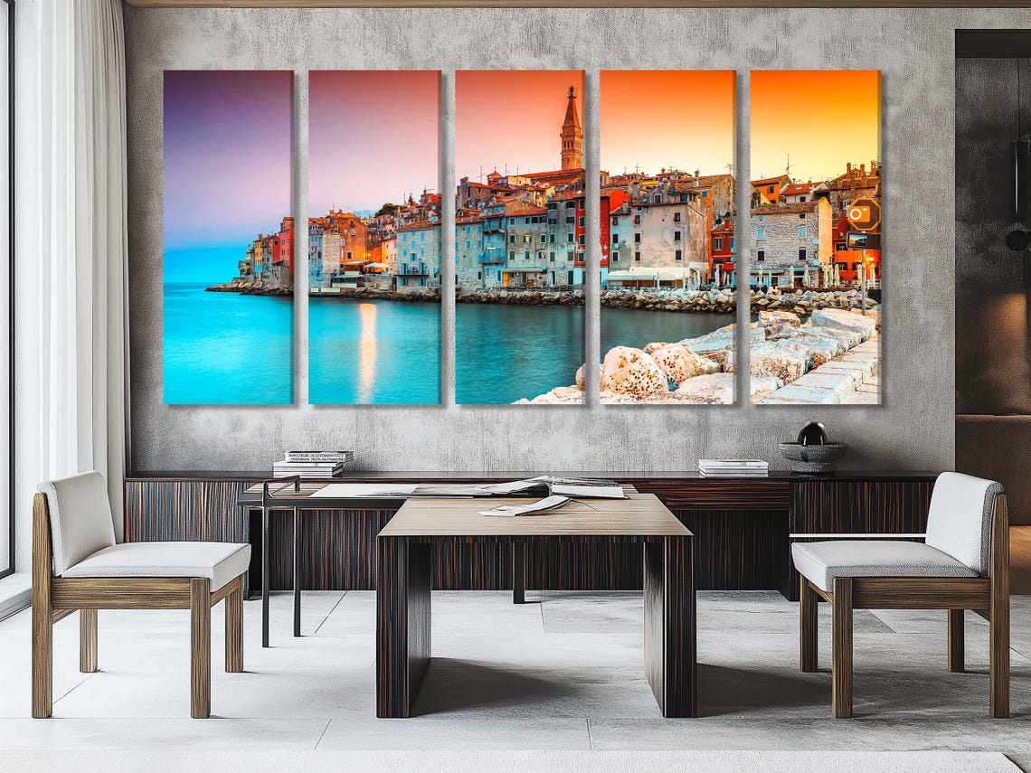 A harbour town at sunset with colourful buildings, a church tower, and turquoise water reflection detail view