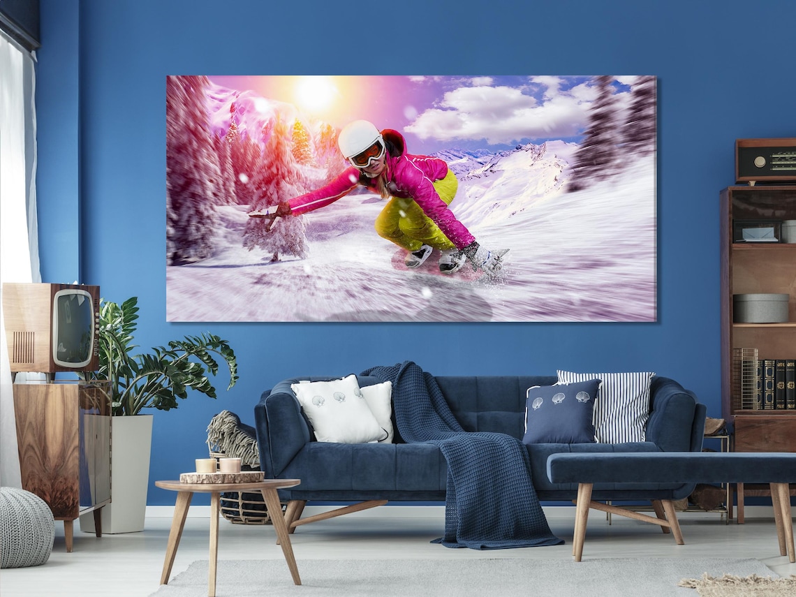 Living room mockup with three framed winter sports artworks showing a snowboarder on snowy mountains
