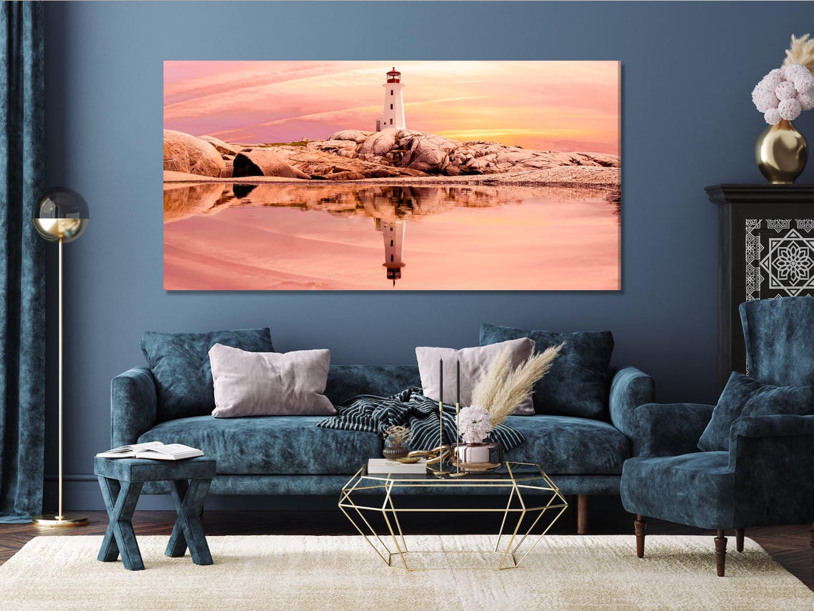 Room mockup with green sofa and a wall display of sunset seascape panels featuring a lighthouse