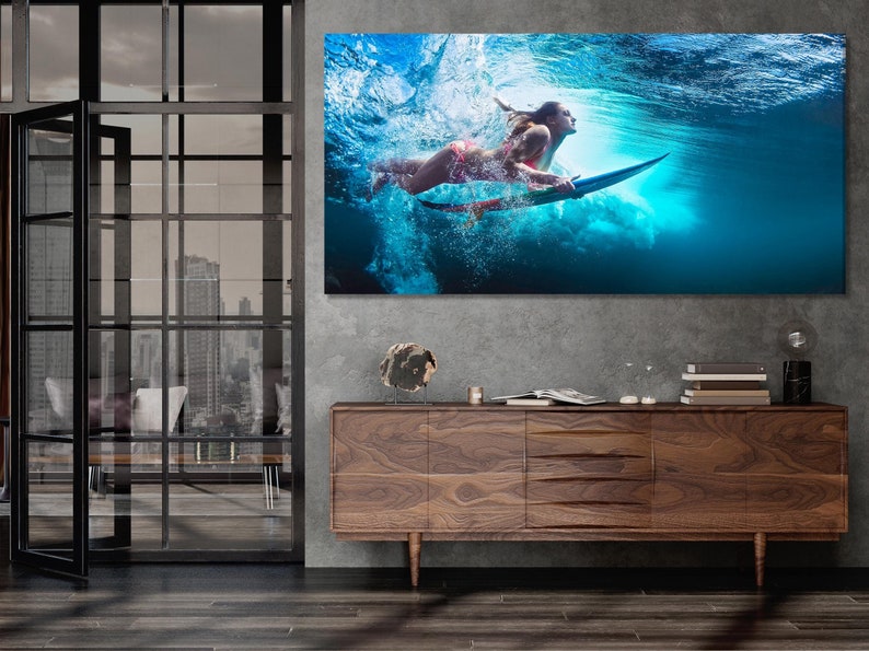 Underwater surfer with a surfboard in bright blue ocean water with bubbles and foamy splashes