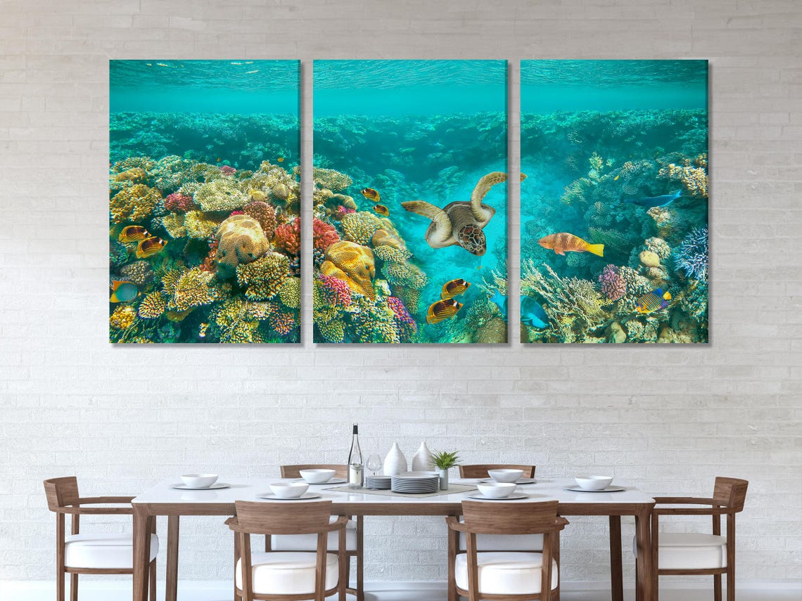 Underwater coral reef scene with a sea turtle swimming among tropical fish in turquoise water detail view