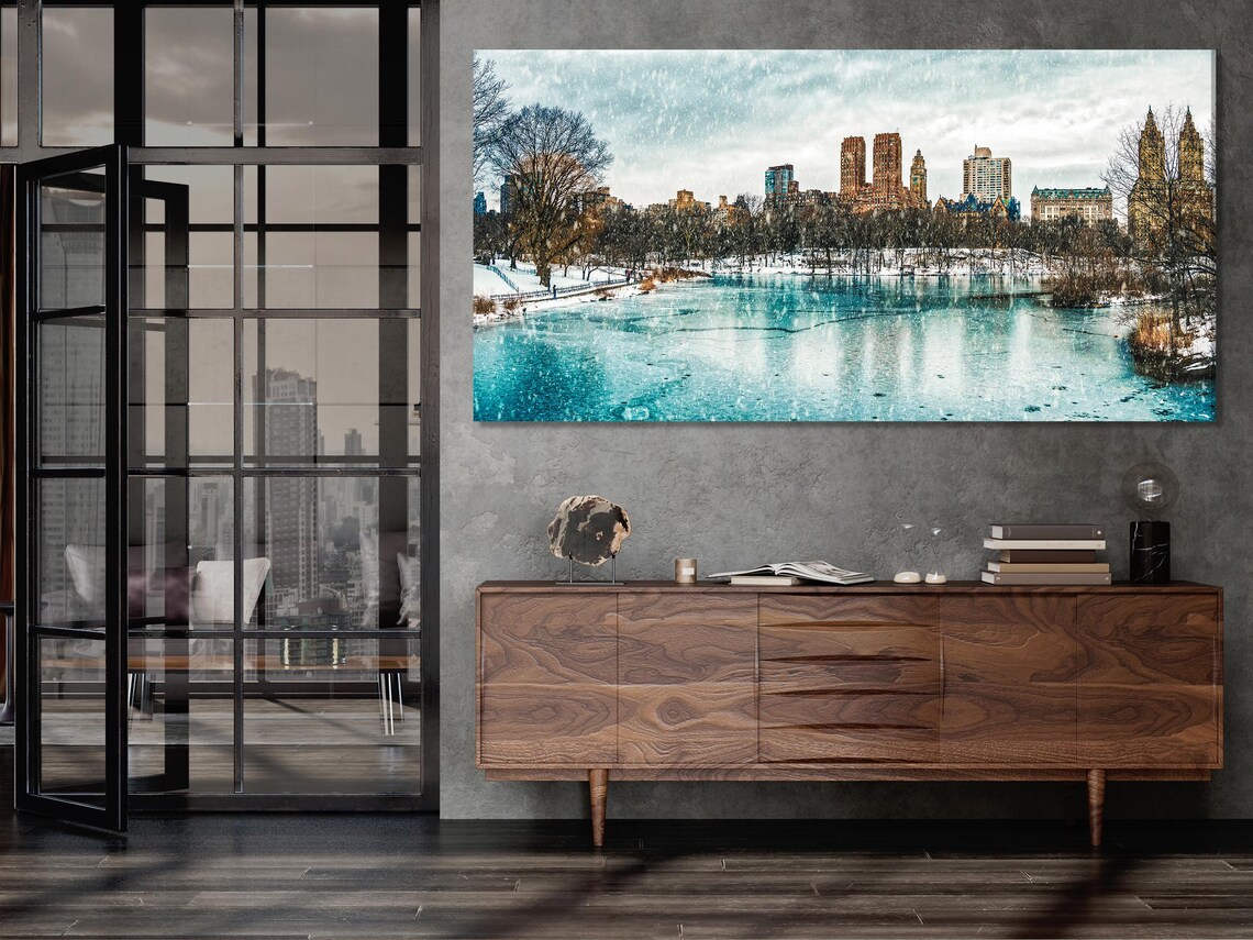 Three winter city skyline artworks displayed above a table in a living room mockup