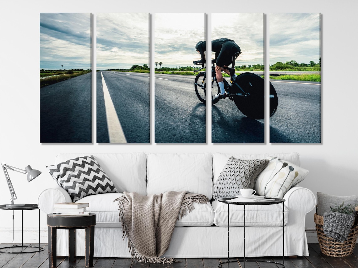 Cyclist riding a road racing bicycle with a forward-leaning posture on a straight road toward a bright horizon detail view