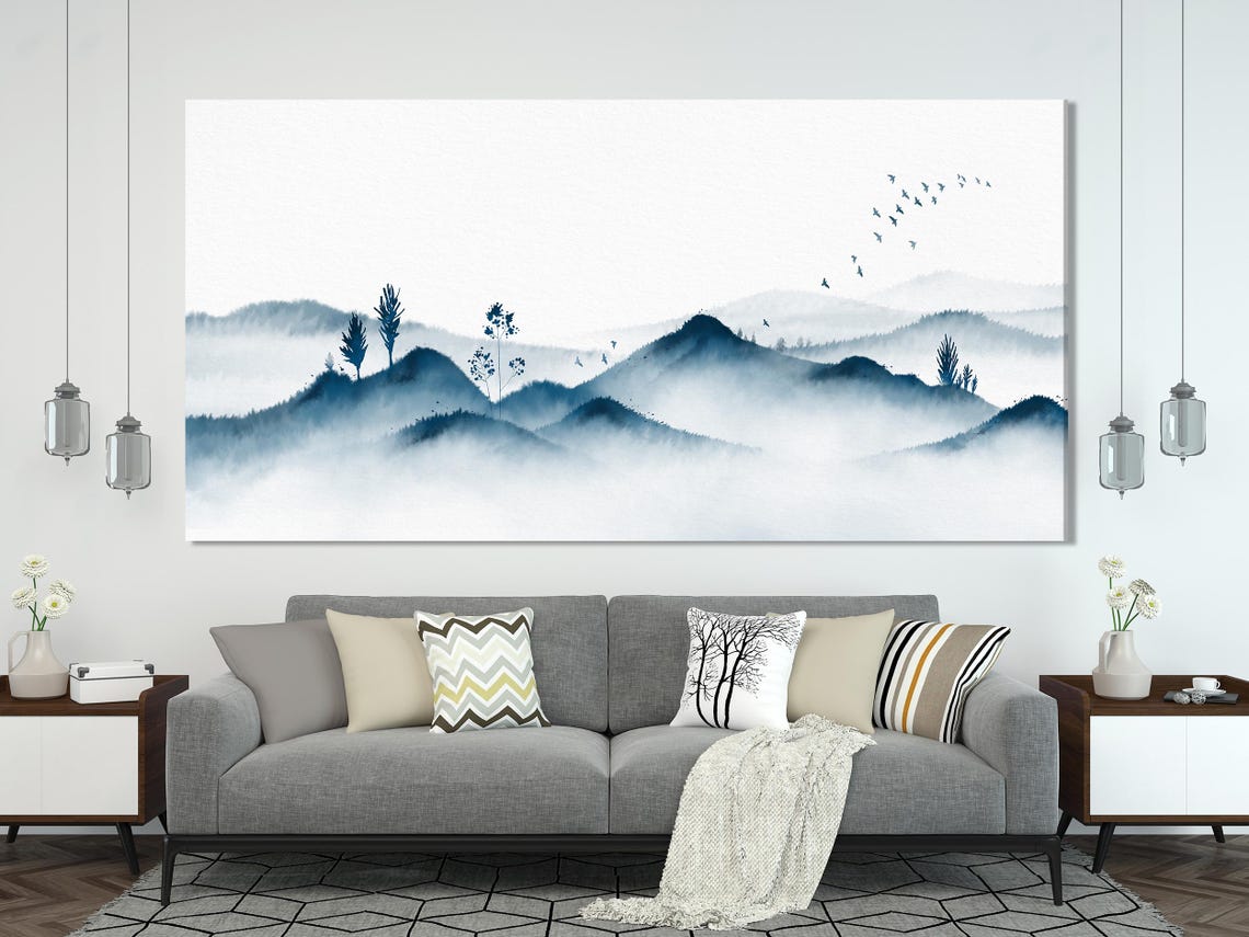 Dining table and chairs with three-panel misty blue mountain artwork on a white wall