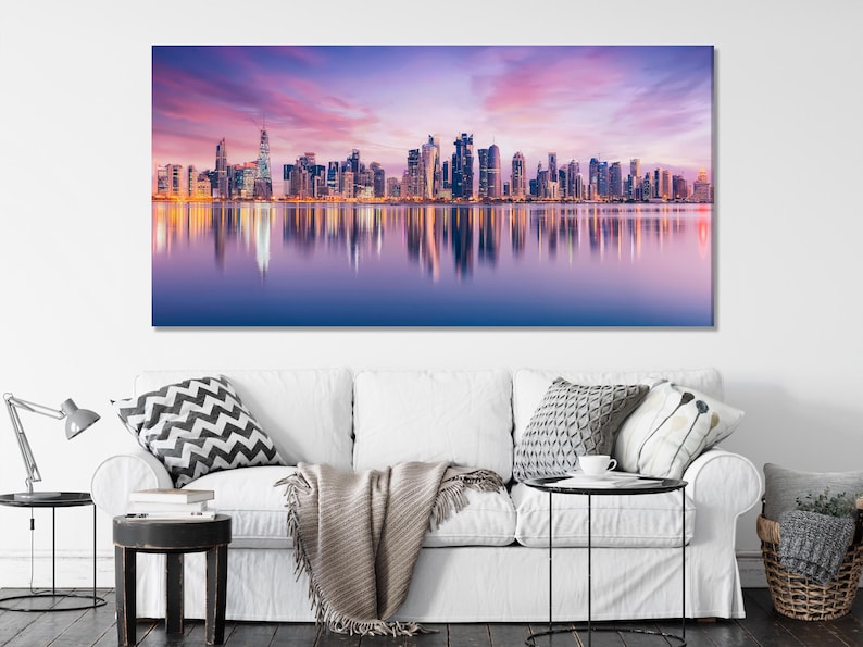 Dusk city skyline with illuminated skyscrapers reflected in calm water