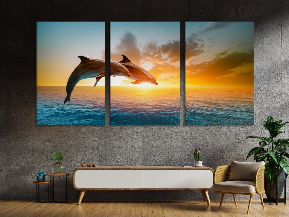 Two dolphins leaping over teal ocean waves under a golden sunset sky detail view
