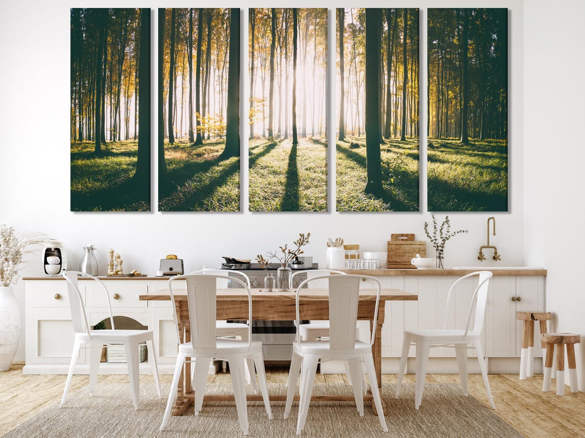 Sunlit forest landscape with tall tree trunks and glowing sunbeams through mist detail view