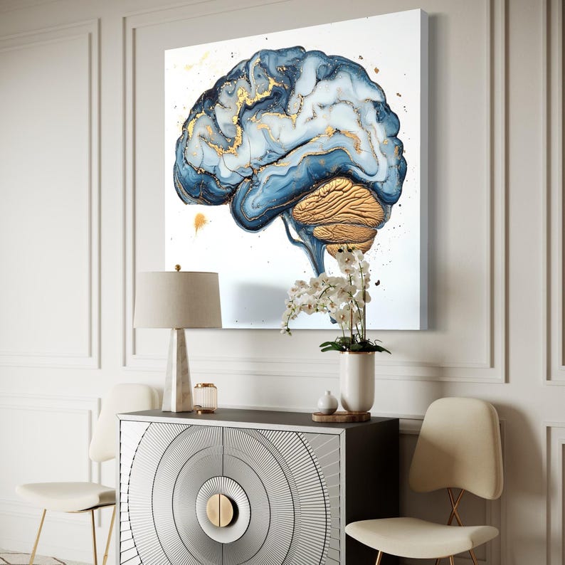 May include: A blue and gold abstract brain painting on a white canvas. The brain is depicted in a realistic style with detailed anatomical features. The painting is framed and hanging on a white wall.