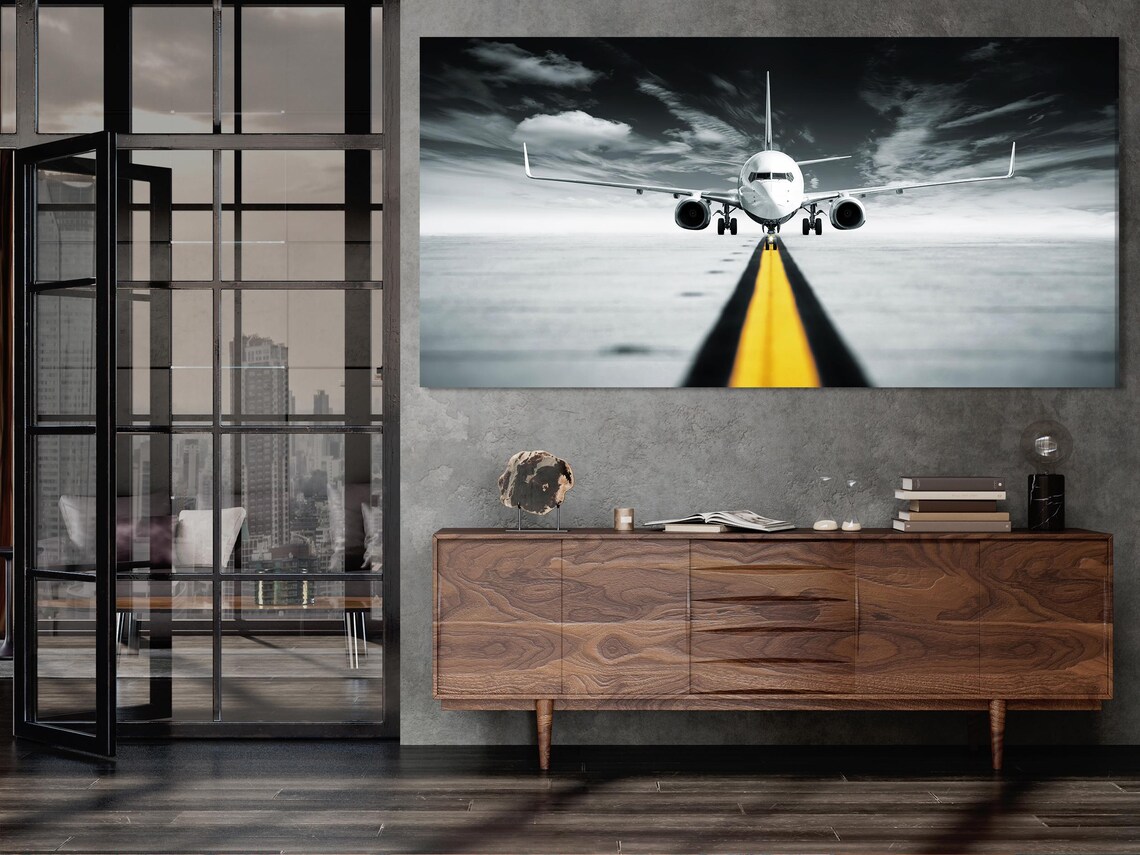 A room mockup with a wall display of black and white jet airplane runway artwork