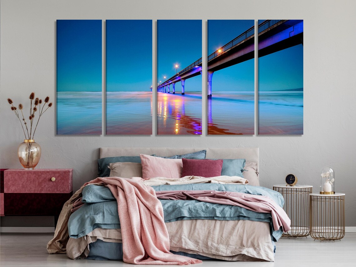 Three-panel night seascape showing an illuminated pier and glowing reflections on calm ocean water detail view