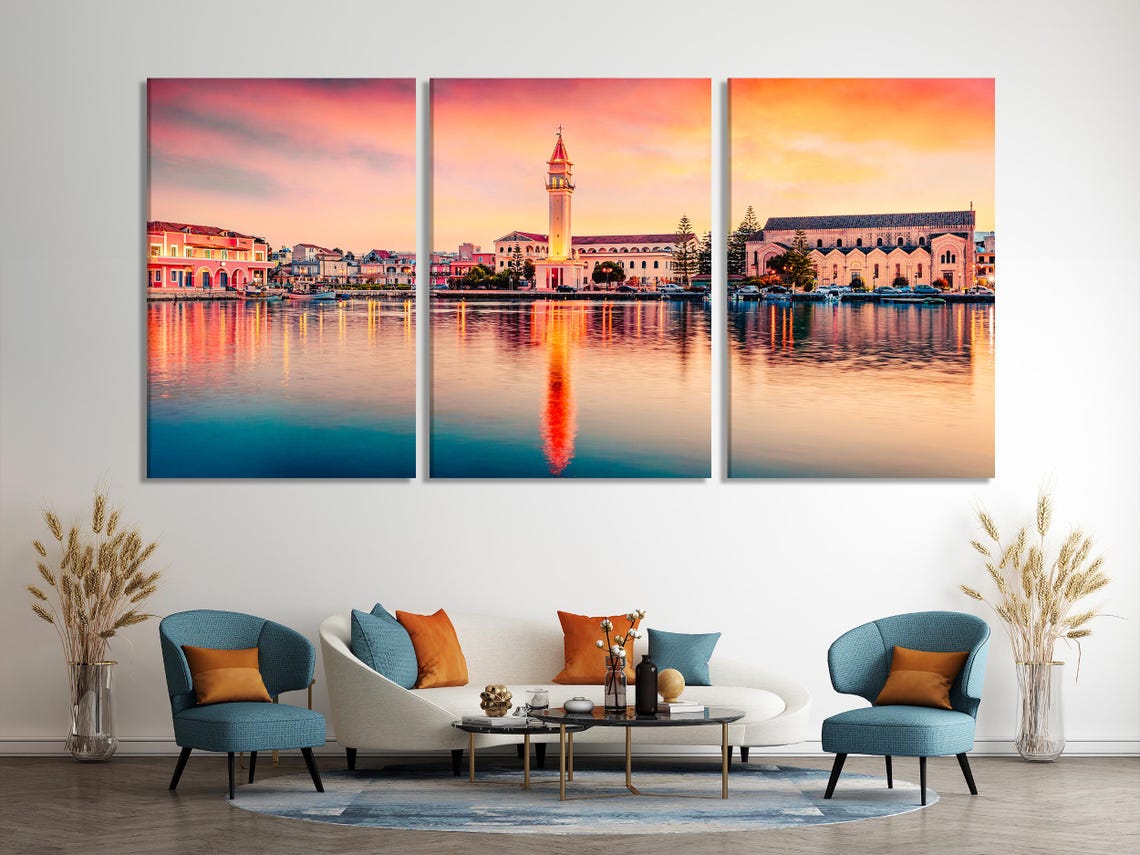 Sunset coastal town with a church tower and mirrored reflections on calm water detail view