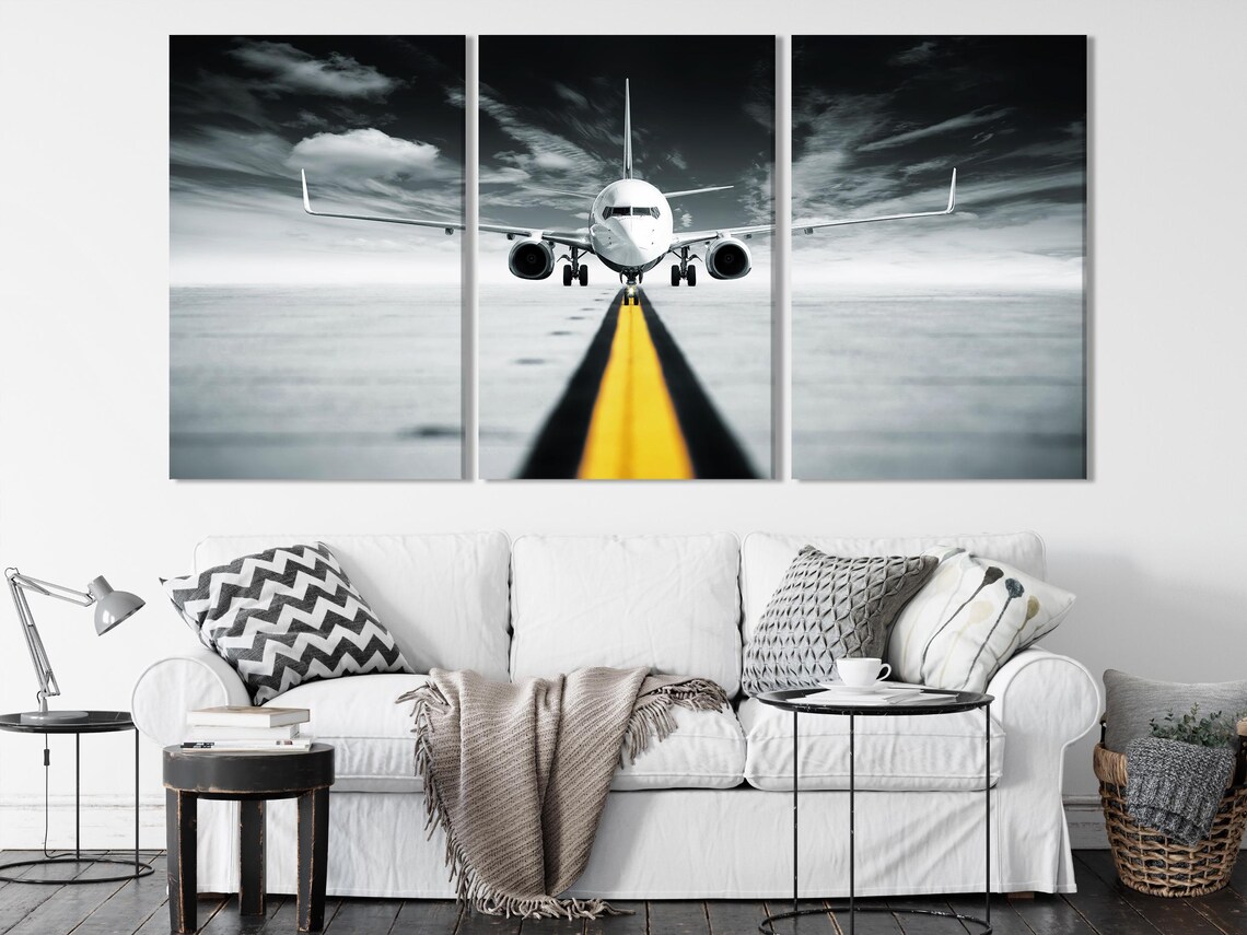 A room mockup with a wall display of black and white jet airplane runway artwork