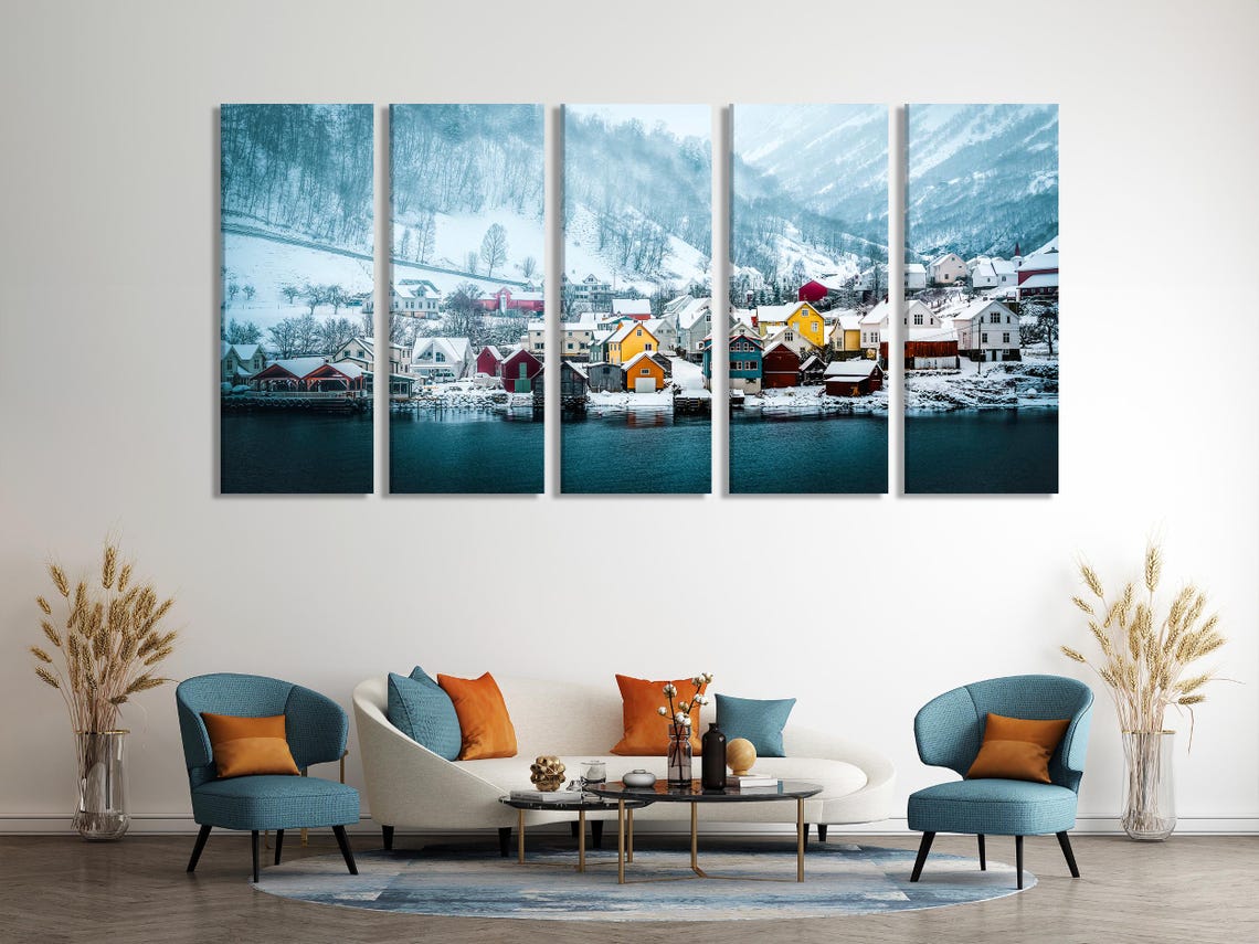 Winter village artwork displayed on a wall above a dining table