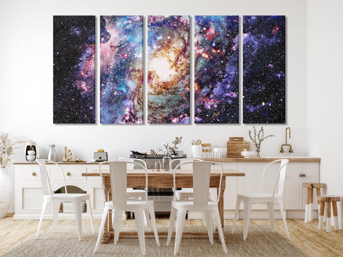 A star-filled nebula scene swirls in deep black space, with bright white cores and colourful purple, blue, pink and orange clouds across the detail