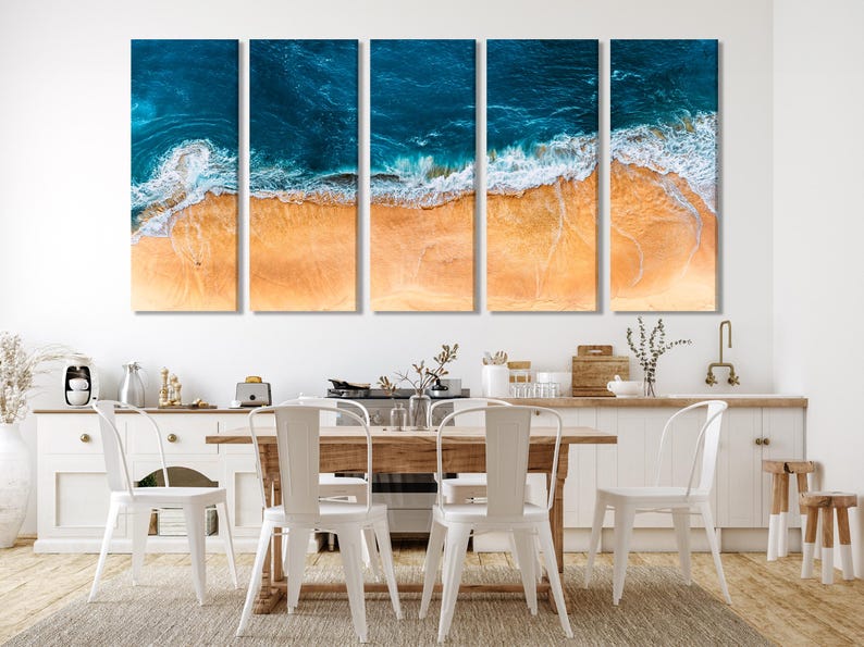 Aerial view of turquoise ocean waves breaking over warm sandy beach with white foam