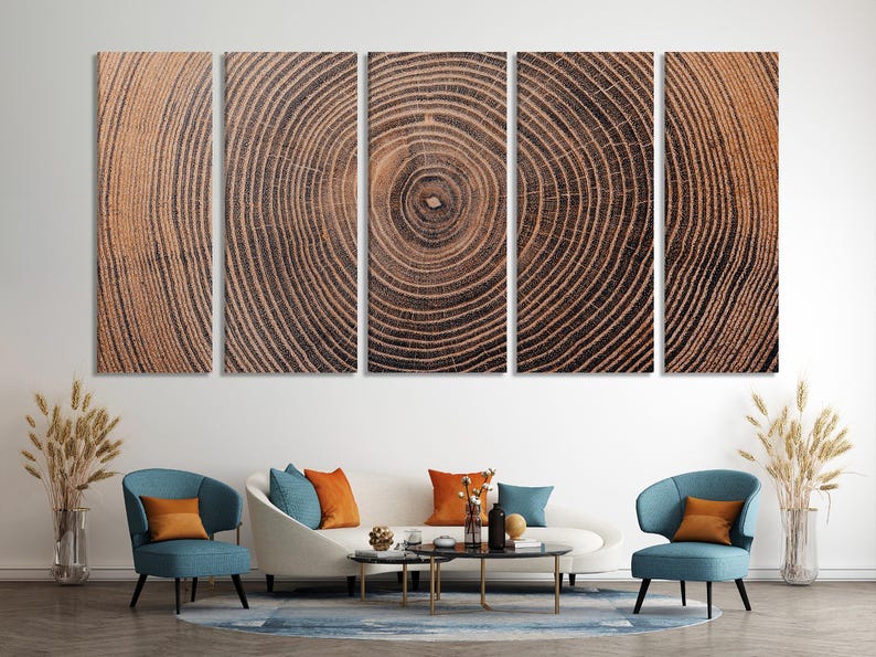 A five-panel wall art set featuring a continuous, high-resolution print of a tree trunk cross-section. The image displays concentric growth rings in shades of brown, tan, and dark charcoal, creating a detailed wood grain texture.