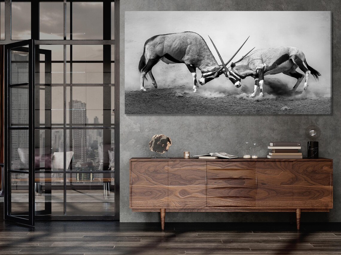 Triptych black-and-white wildlife artwork above a dining table in a bright room