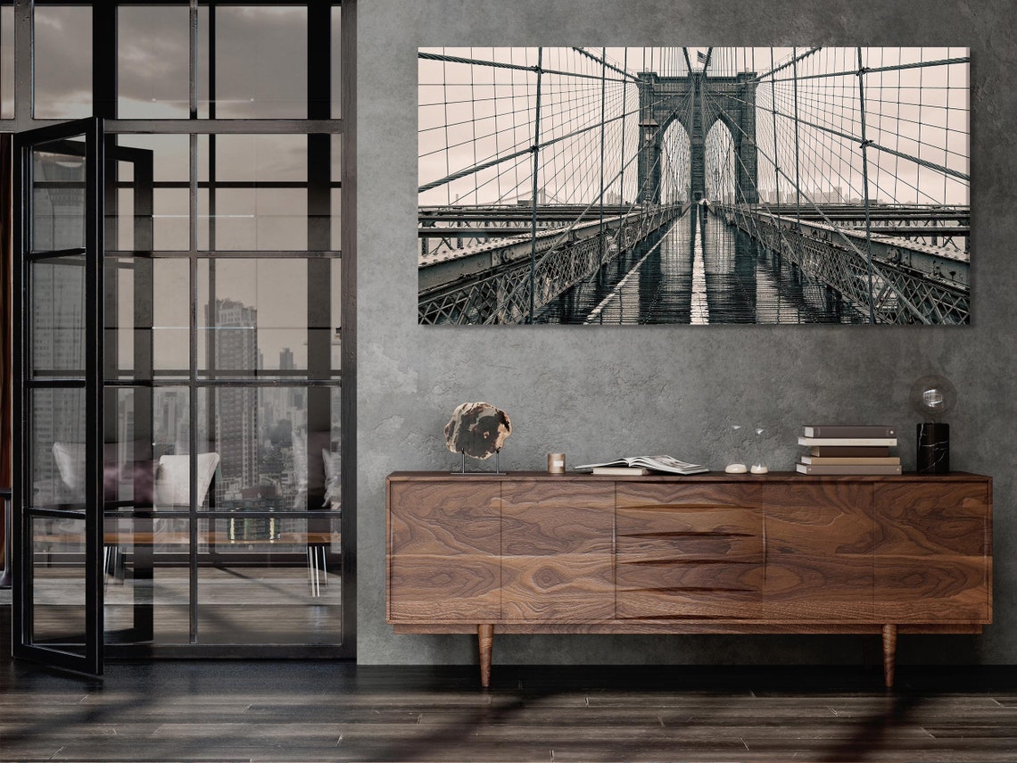 Room mockup showing a black-and-white bridge artwork above a green sofa
