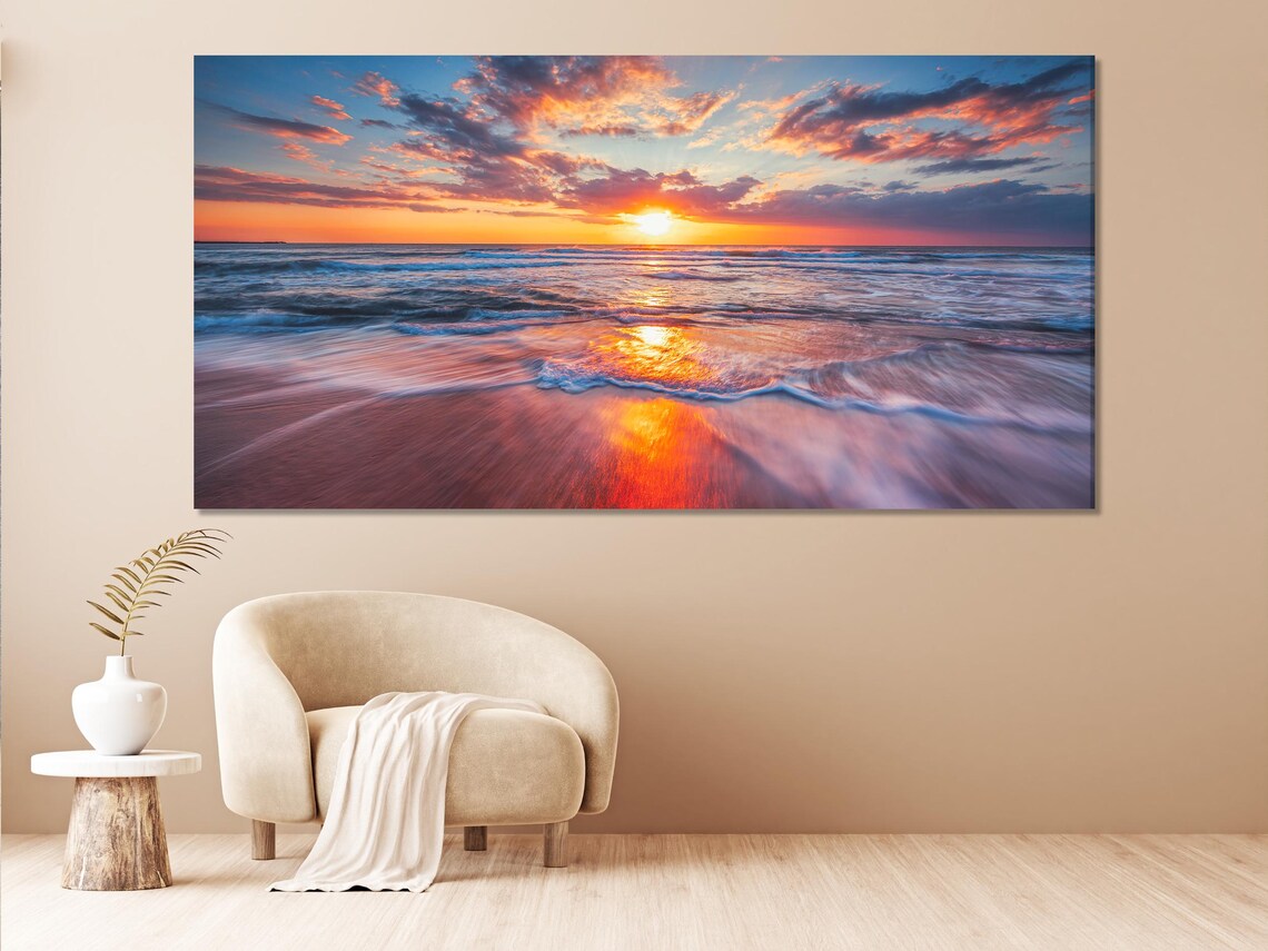 Living room mockup with blue sofa and multi-panel ocean sunset artwork on the wall