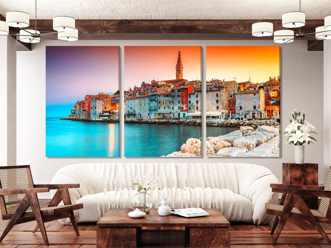 A harbour town at sunset with colourful buildings, a church tower, and turquoise water reflection detail view