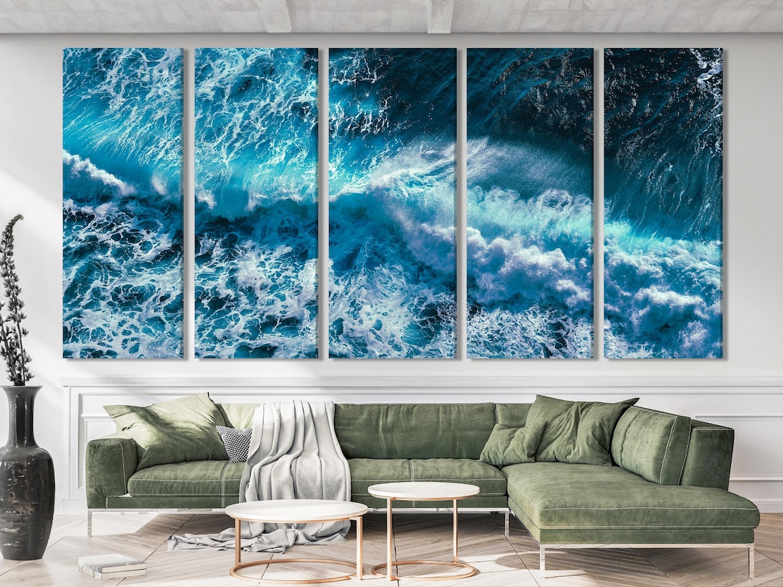 Ocean waves triptych artwork above a dining table in a bright coastal-style room