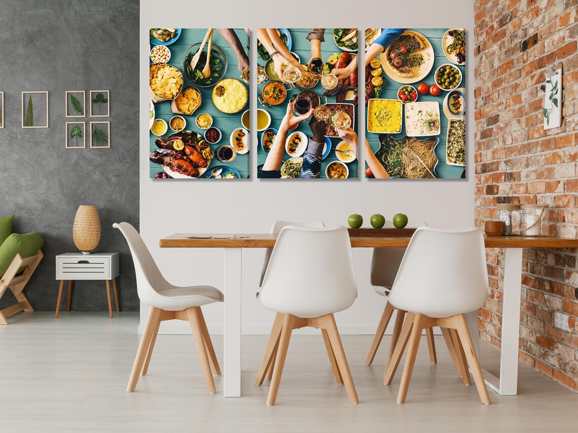 Dining table scene with a wall-hung artwork showing an overhead dinner with wine glasses