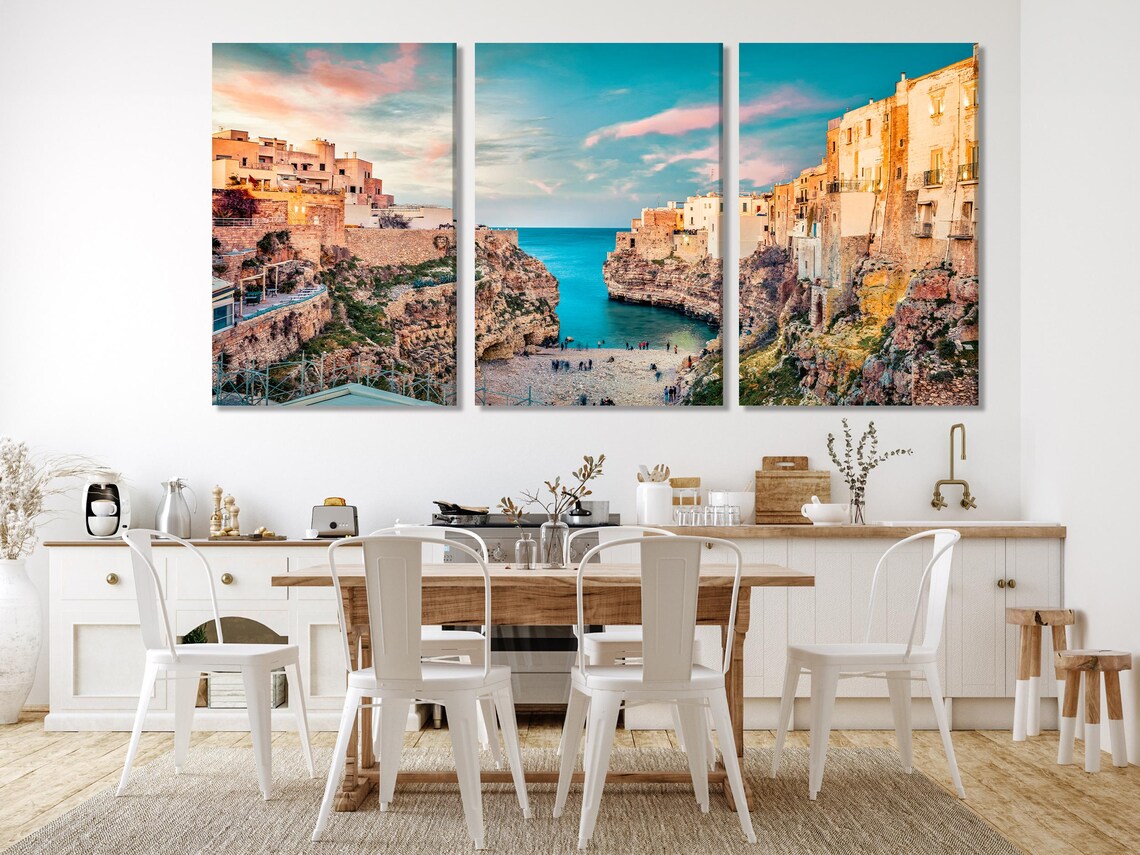 Sunlit cliffside town overlooking a sheltered bay with turquoise blue water and a pastel sky detail view