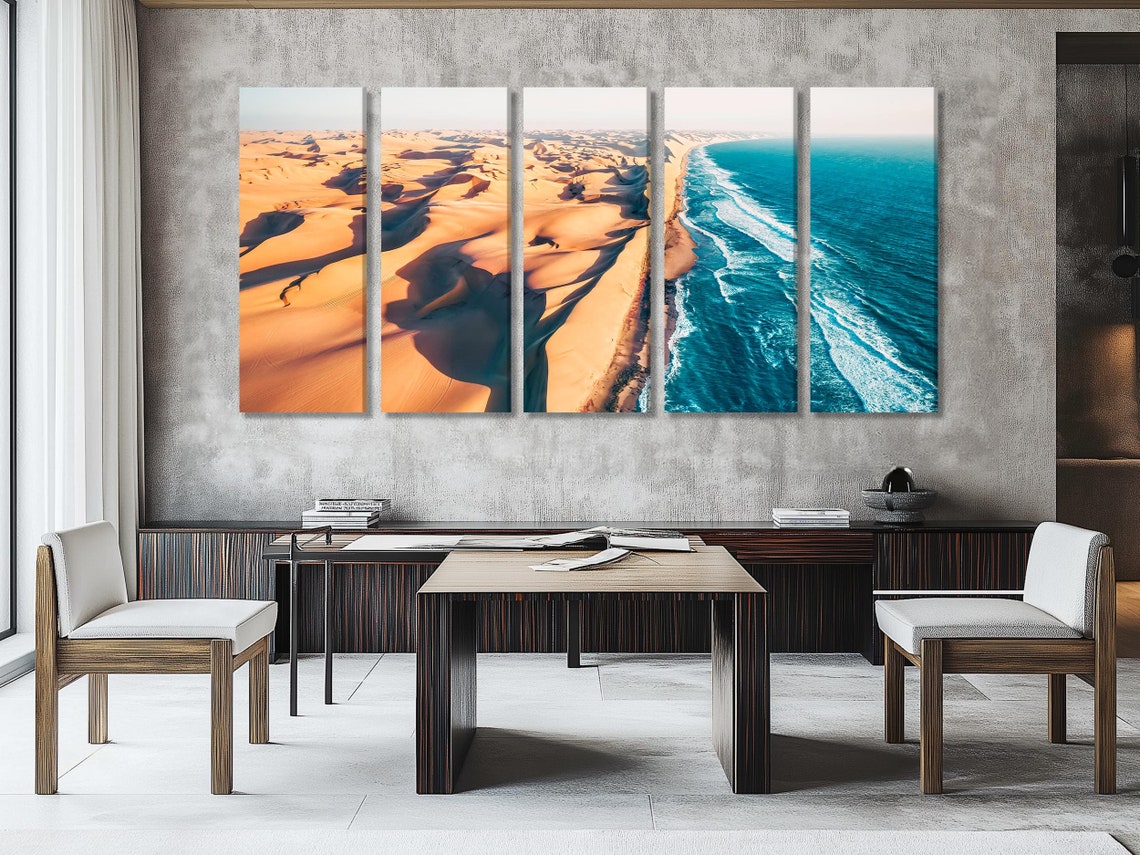 Aerial view of golden desert dunes meeting bright blue ocean waves along a curving shoreline detail view