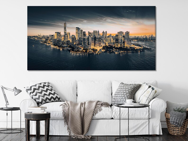 Manhattan skyline at dusk with a tall tower, warm city lights, clouds and dark water reflections