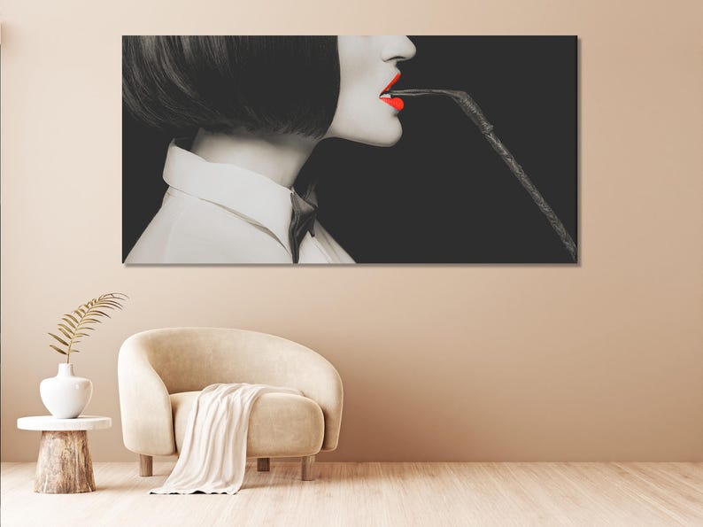 Black-and-white side-profile portrait with vivid red lips and a dark whip-like curve