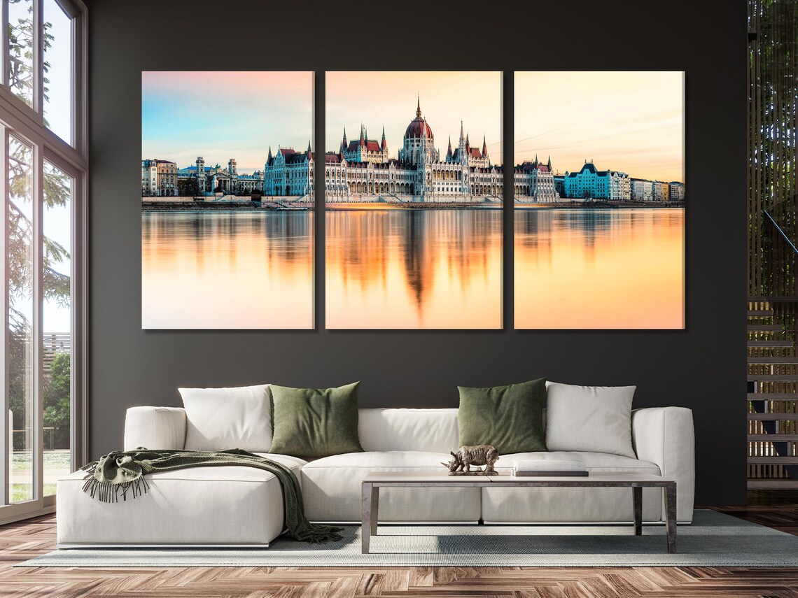 Living room with green sofa and five-panel sunset cityscape skyline artwork above