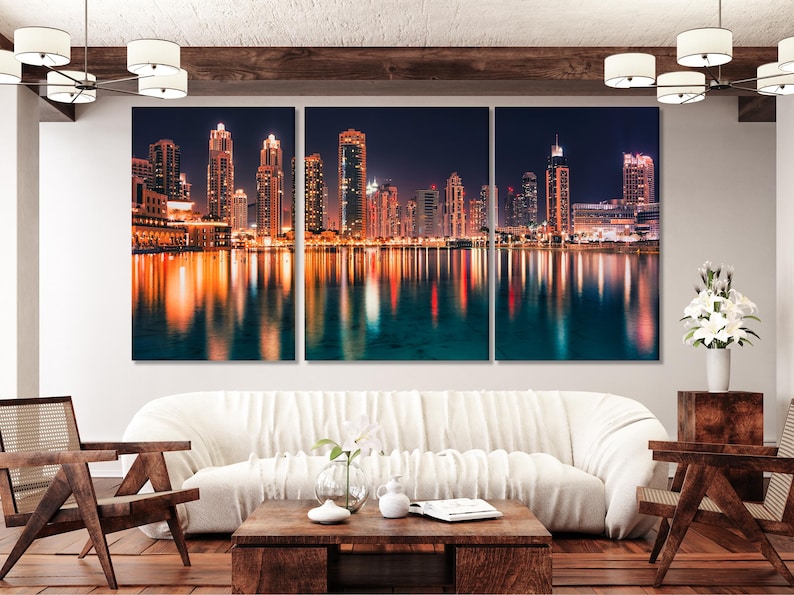 Three-panel night city skyline with illuminated skyscrapers and reflections on water