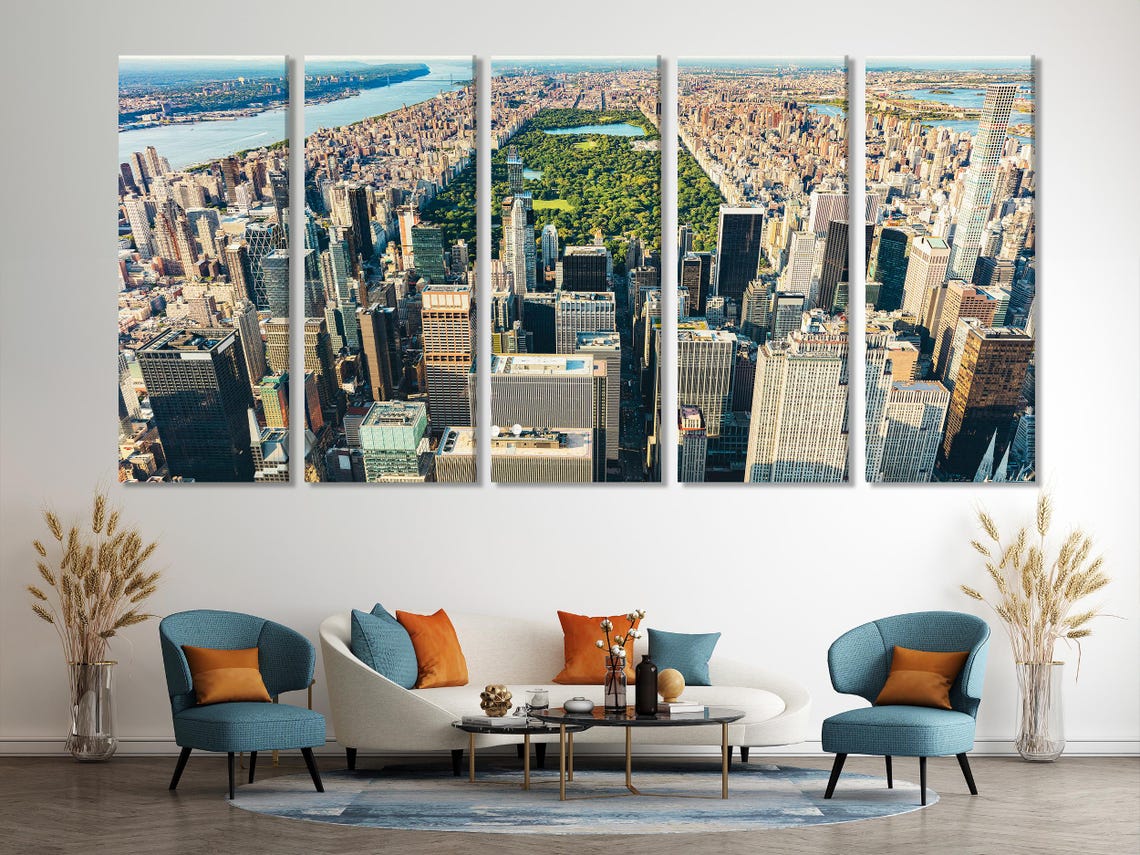 Room mockup showing three panels of a New York skyline aerial cityscape above a sofa