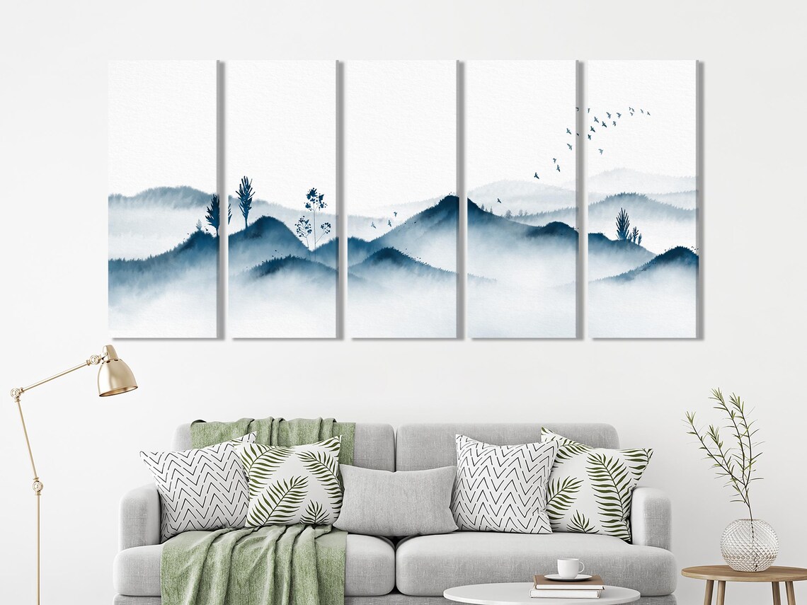 Dining table and chairs with three-panel misty blue mountain artwork on a white wall