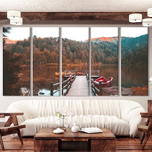 Peut inclure: Une impression sur toile multi-panneaux représentant un paysage pittoresque d'un lac entouré d'arbres aux couleurs automnales. Une jetée en bois s'étend dans l'eau avec plusieurs bateaux rouges et jaunes amarrés.