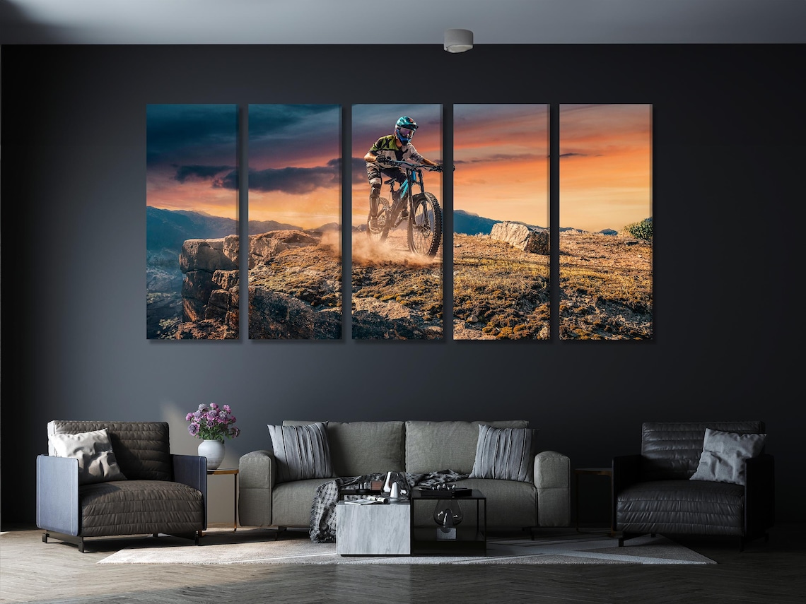 Mountain biker sunset wall artwork displayed above a blue sofa in a living room