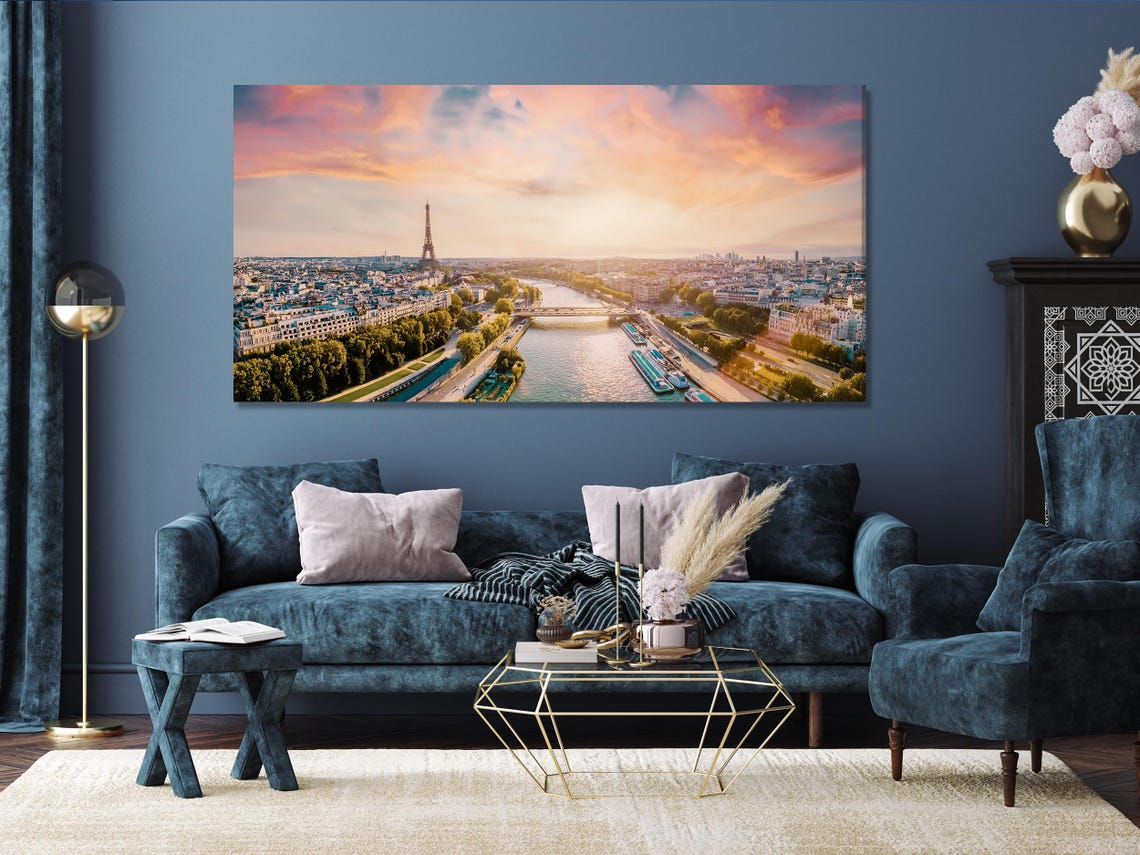 A warm-toned aerial city view of Paris across multiple panels, with a tall metal tower and a river curving through parks and buildings under a pastel