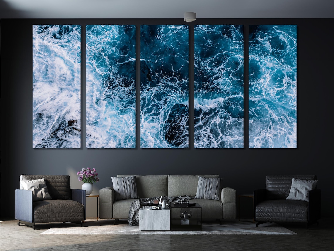 Ocean wave wall artwork above a sofa and table in a bright interior