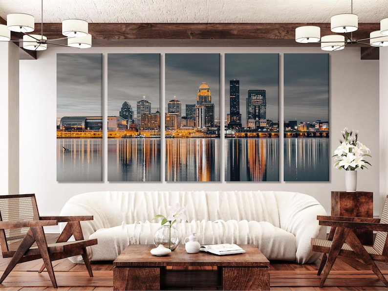 Night city skyline with illuminated buildings and reflections on calm water under a cloudy blue sky