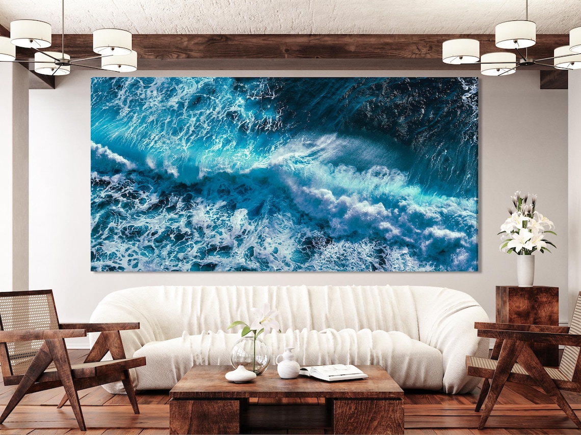 Ocean waves triptych artwork above a dining table in a bright coastal-style room