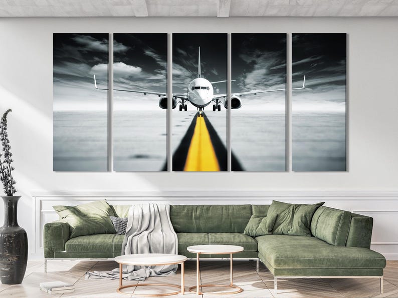 Black and white jet airplane facing forward on a runway with a yellow centre line