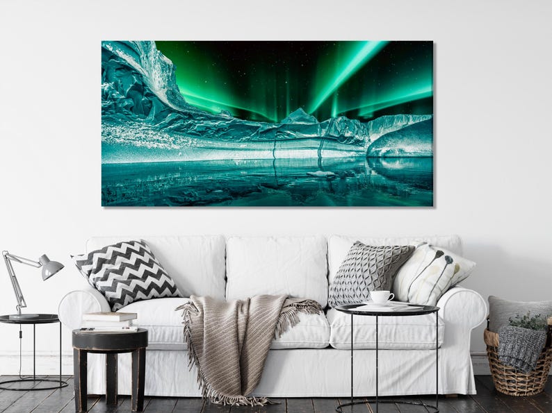 Northern lights over an icy arctic landscape with green aurora glow and reflections on water