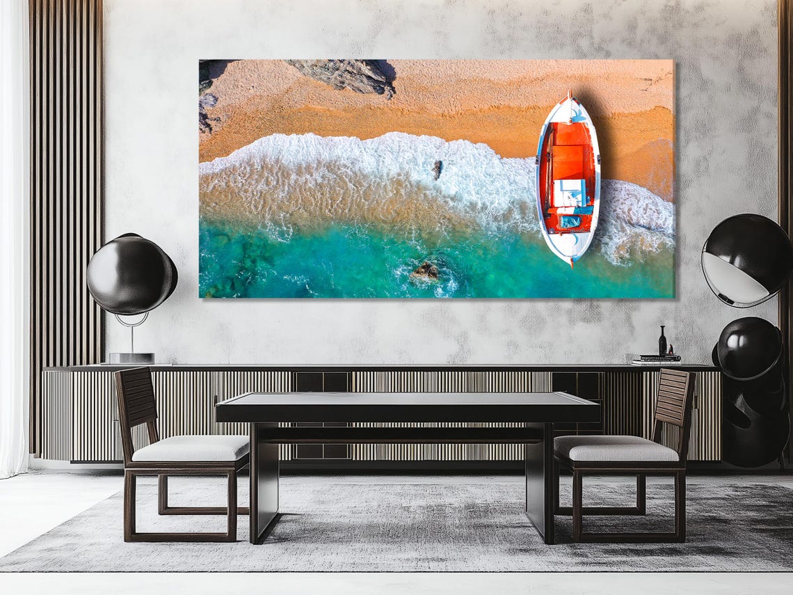 Room mockup showing three coastal panels with an orange fishing boat over turquoise water and foam
