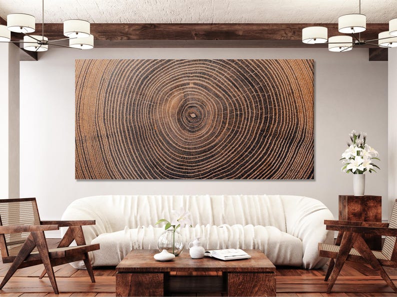 A large rectangular wall art piece featuring a high-resolution print of a tree trunk cross-section. The image displays concentric growth rings in shades of dark brown, black, and light tan, radiating from a central point.