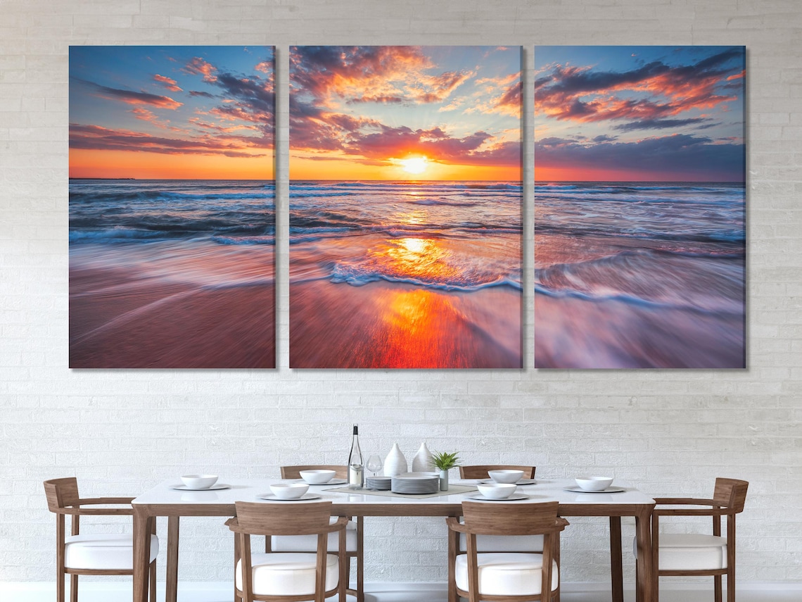 Living room mockup with blue sofa and multi-panel ocean sunset artwork on the wall