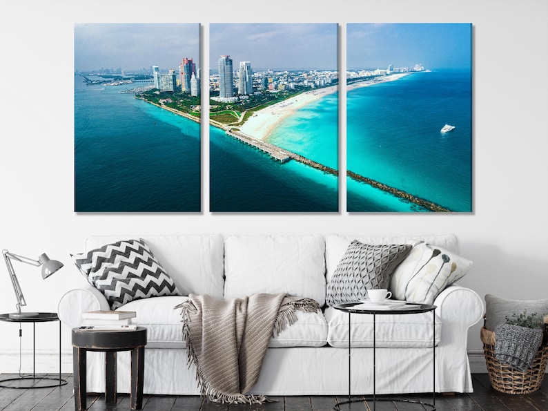 Aerial coastal city scene with turquoise ocean, sandy beach, seawall and high-rise buildings