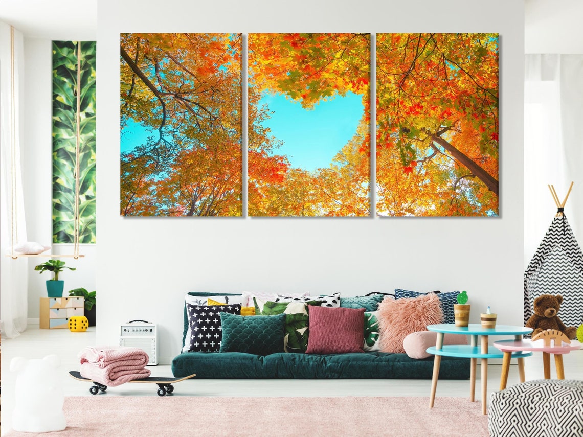 Autumn forest canopy with tree branches and dense fall leaves framing a bright blue sky detail view